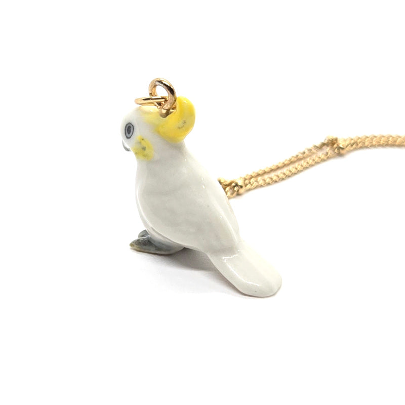 Back view of a ceramic Yellow-crested cockatoo pendant on a gold-plated stainless steel beaded chain.