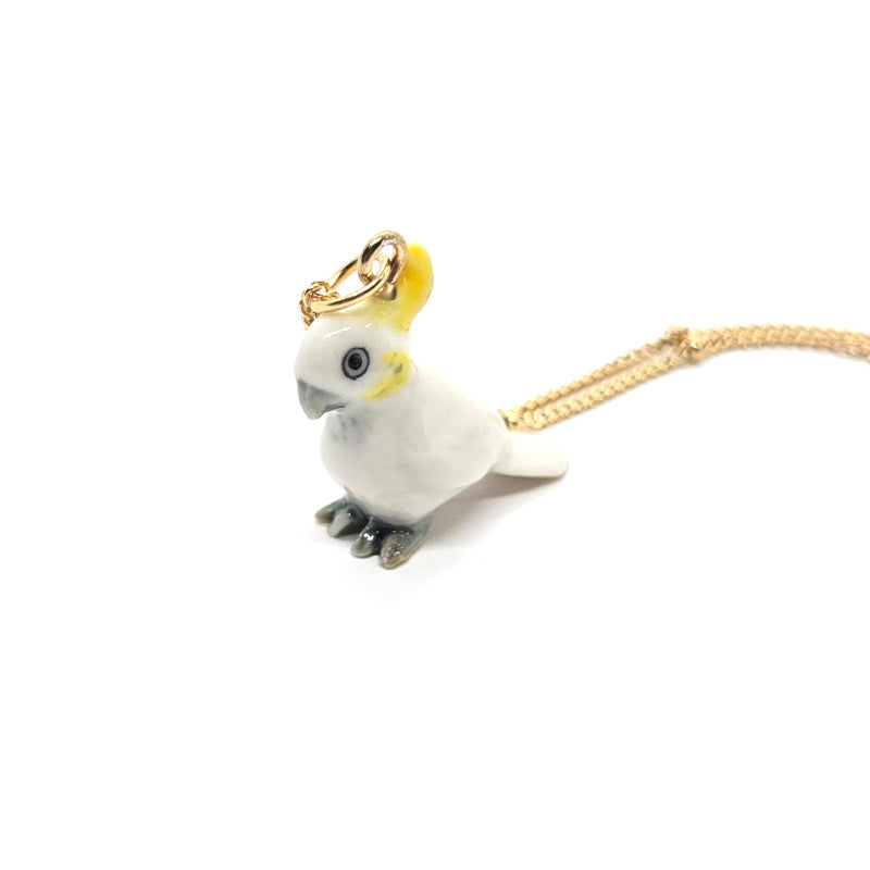 Side view of ceramic Yellow-crested cockatoo pendant on a gold-plated stainless steel beaded chain.