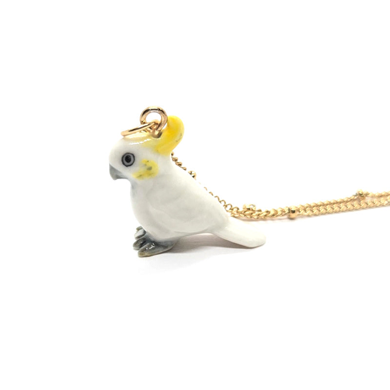 Left side view of ceramic Yellow-crested cockatoo pendant on a gold-plated stainless steel beaded chain.