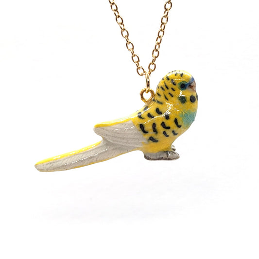 Yellow parakeet or budgie suspended from a gold-plated stainless steel cable chain