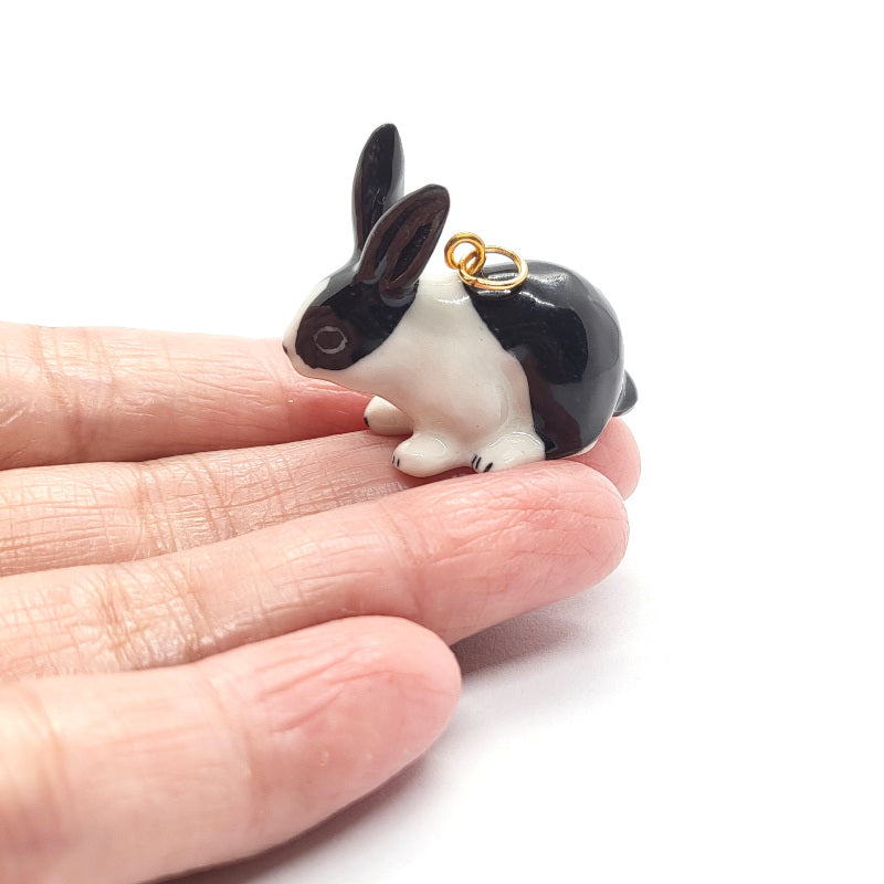 Dutch black and white rabbit ceramic pendant on finger